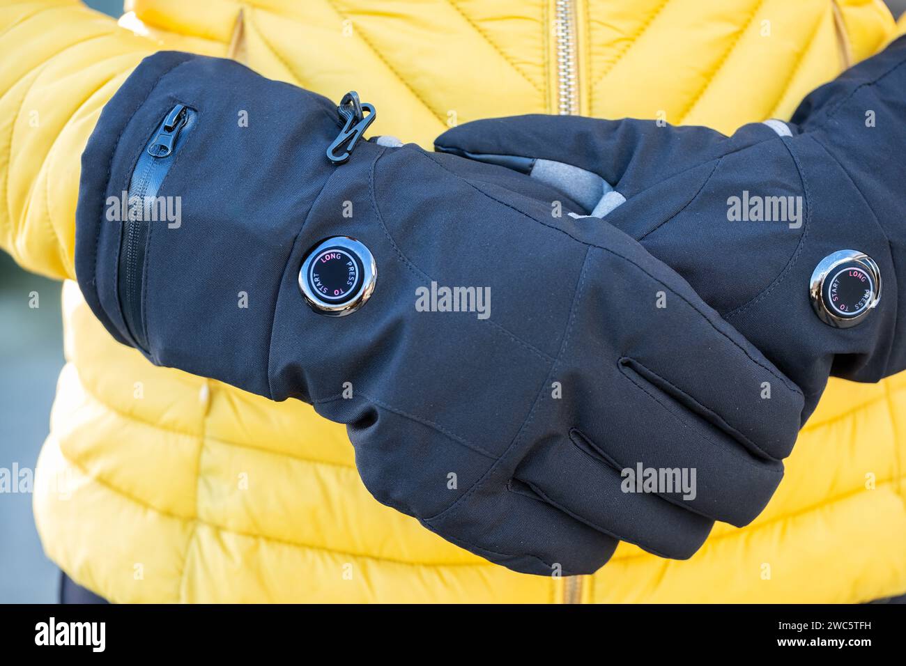 Une femme portant des gants chauffés par batterie par temps froid. Les gants ont des réglages de chaleur variables et aident ceux qui souffrent de la maladie de Reynauds Banque D'Images