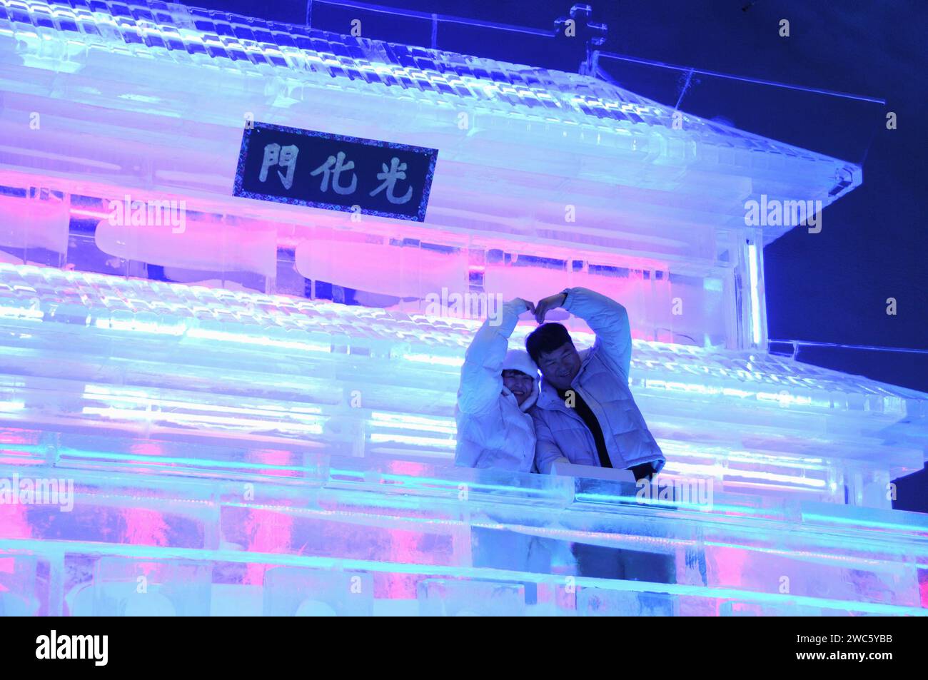 Province de Gangwon, Corée du Sud. 13 janvier 2024. Les touristes posent pour des photos devant les statues de Gwanghwamun réalisées par les sculpteurs de glace Harbin lors du festival de glace de Hwacheon Sancheoneo dans la province de Gangwon, Corée du Sud, le 13 janvier 2024. Capitale de la province la plus septentrionale de la Chine, Heilongjiang, Harbin est réputée pour être le « joyau de la glace et de la neige » du pays. Cette année, les sculpteurs de glace de Harbin ont été invités à créer des sculptures de glace pour le festival de glace de Hwacheon Sancheoneo, l'un des festivals d'hiver sud-coréens les plus populaires. Crédit : Yang Chang/Xinhua/Alamy Live News Banque D'Images