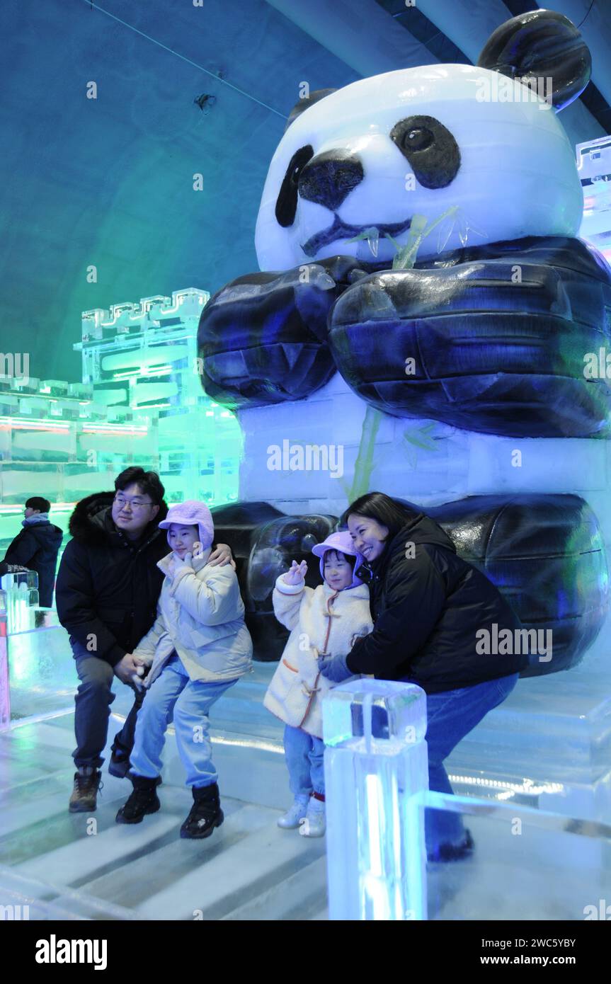 Province de Gangwon, Corée du Sud. 13 janvier 2024. Les touristes posent pour des photos devant les statues de Gwanghwamun réalisées par les sculpteurs de glace Harbin lors du festival de glace de Hwacheon Sancheoneo dans la province de Gangwon, Corée du Sud, le 13 janvier 2024. Capitale de la province la plus septentrionale de la Chine, Heilongjiang, Harbin est réputée pour être le « joyau de la glace et de la neige » du pays. Cette année, les sculpteurs de glace de Harbin ont été invités à créer des sculptures de glace pour le festival de glace de Hwacheon Sancheoneo, l'un des festivals d'hiver sud-coréens les plus populaires. Crédit : Yang Chang/Xinhua/Alamy Live News Banque D'Images