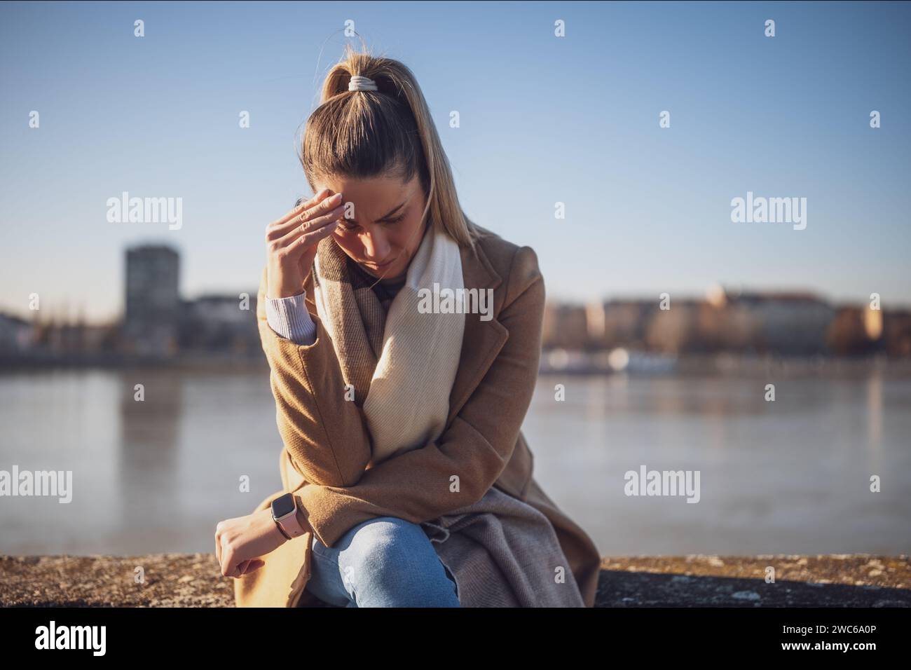 Femme inquiète ayant mal à la tête tout en étant assis par la River.toned image. Banque D'Images