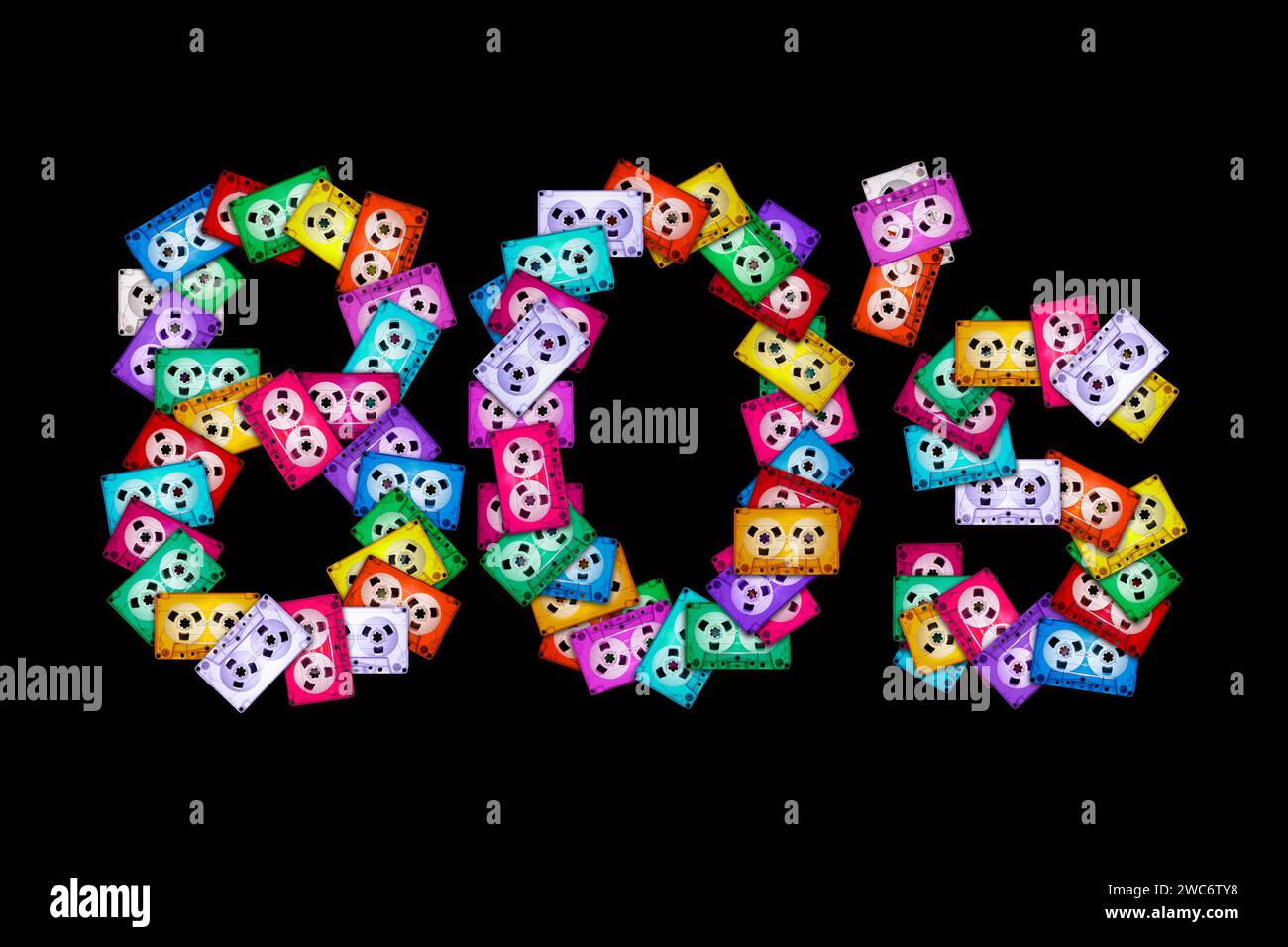 Vue de dessus du texte '80'' sur fond noir isolé, composé de cassettes audio colorées anciennes et mélangées. L'année de la nostalgie pour la maison analogique Banque D'Images