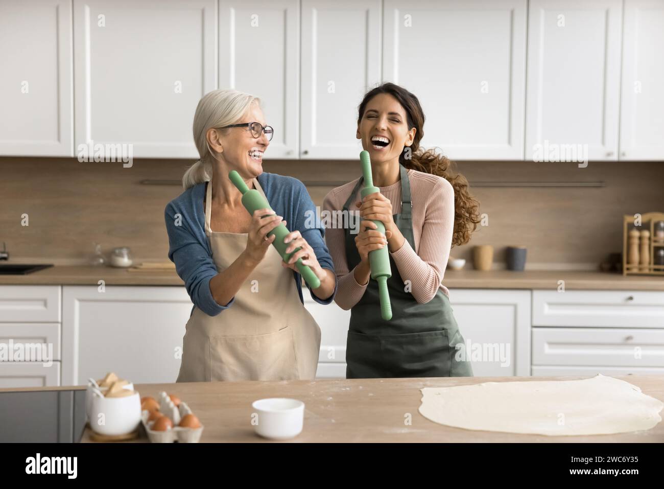 Mère aînée joyeuse et fille adulte appréciant l'activité culinaire Banque D'Images