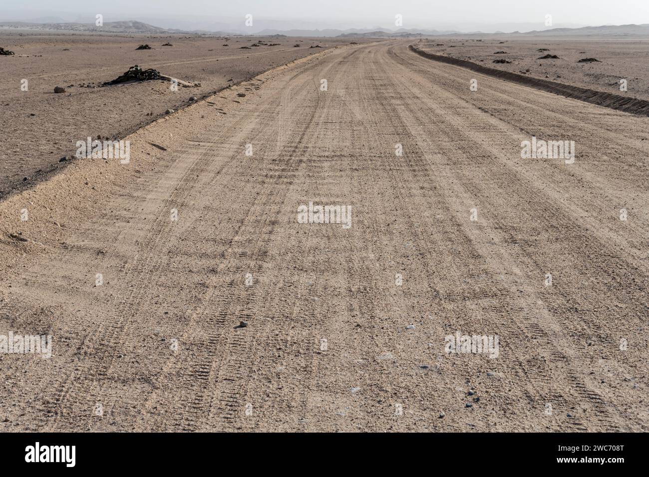Paysage avec route de gravier dans le désert de Moonlandscape , tourné dans la lumière brillante de la fin du printemps près de Swakopmund, Namibie, Afrique Banque D'Images