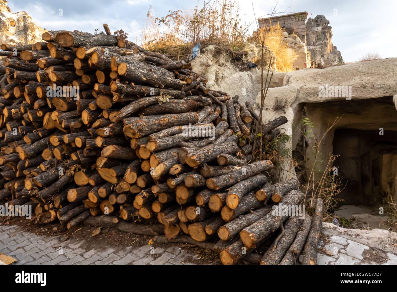 tas de bois de chauffage coupé empilé à côté d'une demeure troglodyte traditionnelle dans l'ancienne région de Cappadoce, en Turquie. Banque D'Images