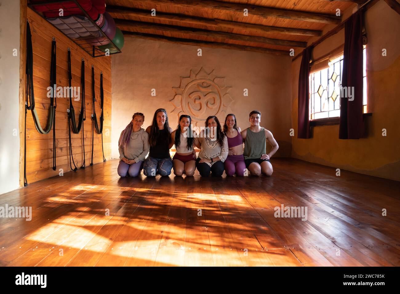 Portrait de groupe d'une communauté de personnes pratiquant le yoga souriant et regardant la caméra. Prise de vue générale éclairée par la lumière naturelle Banque D'Images