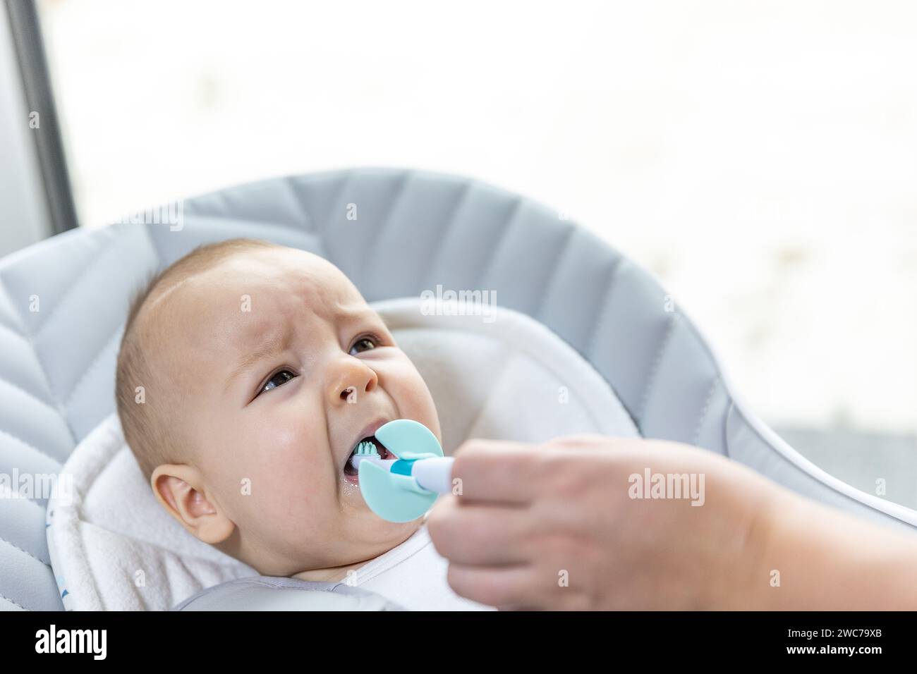 Nouveau-né souffrant de la croissance de ses dents, maman utilisant un anneau de dentition pour soulager la douleur, concept de soins de santé Banque D'Images