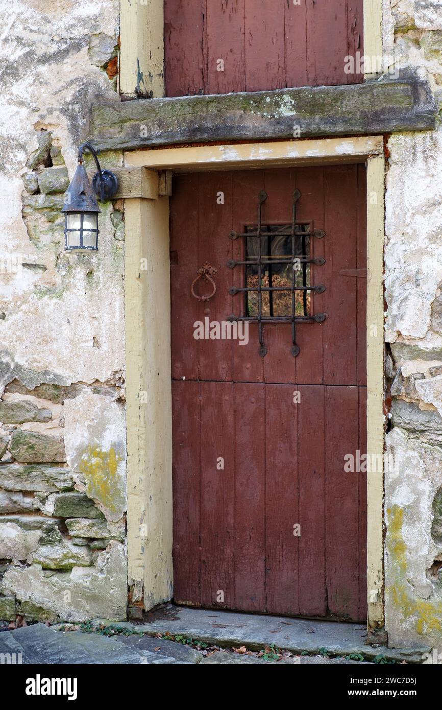 La porte rouge est l'entrée de cette vieille maison en pierre. Banque D'Images