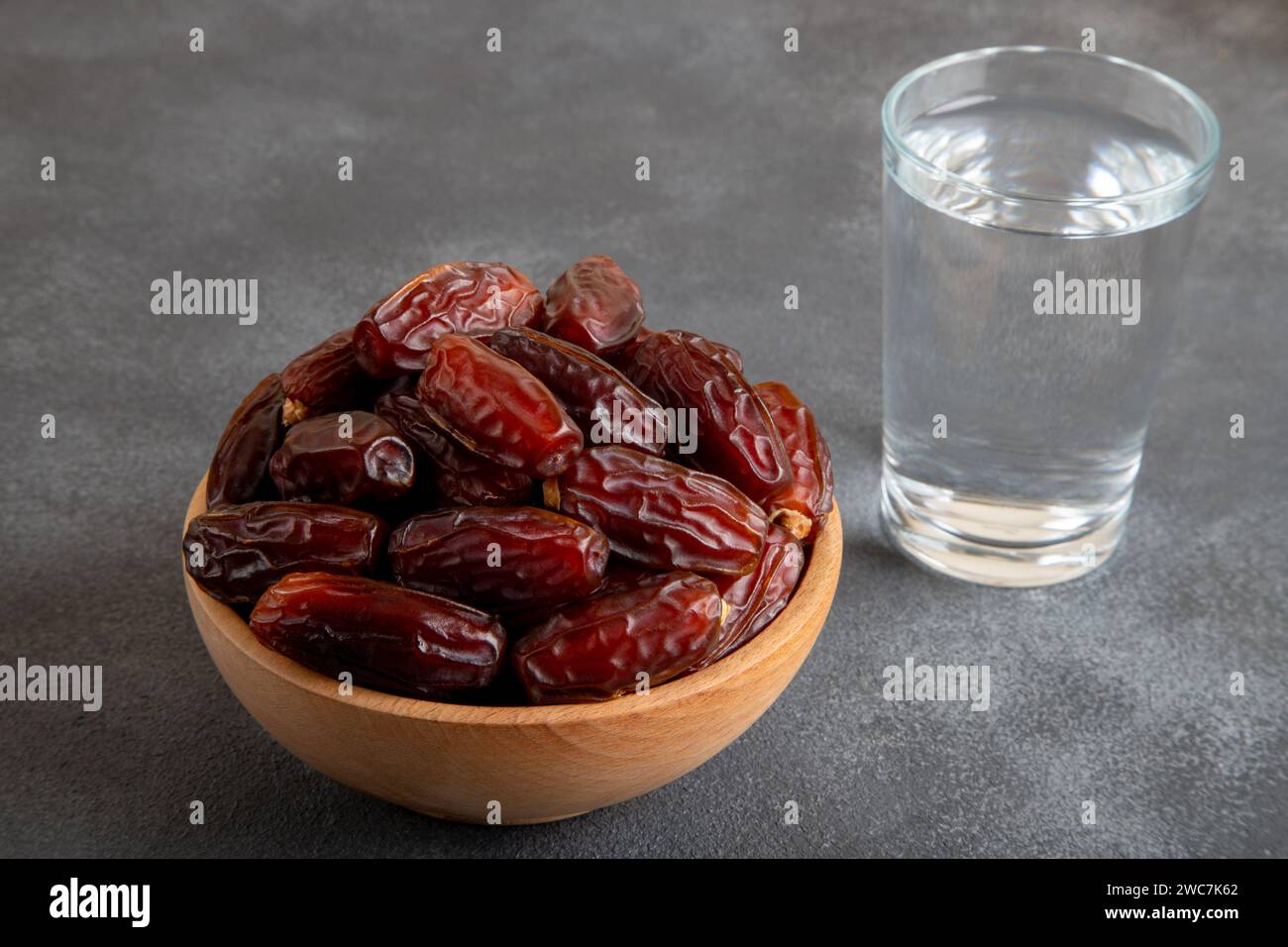 Verre d'eau, datez les fruits sur fond noir Banque D'Images