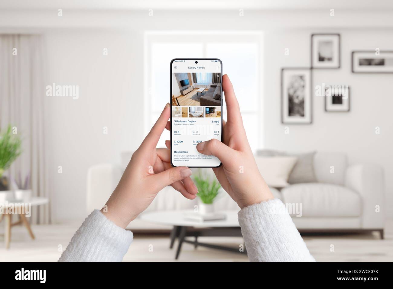 Les mains d'une femme tiennent un smartphone dans l'intérieur d'un salon. Utilisation d'une application de maisons de luxe pour rechercher un loyer, alliant technologie moderne et sophistiquée Banque D'Images