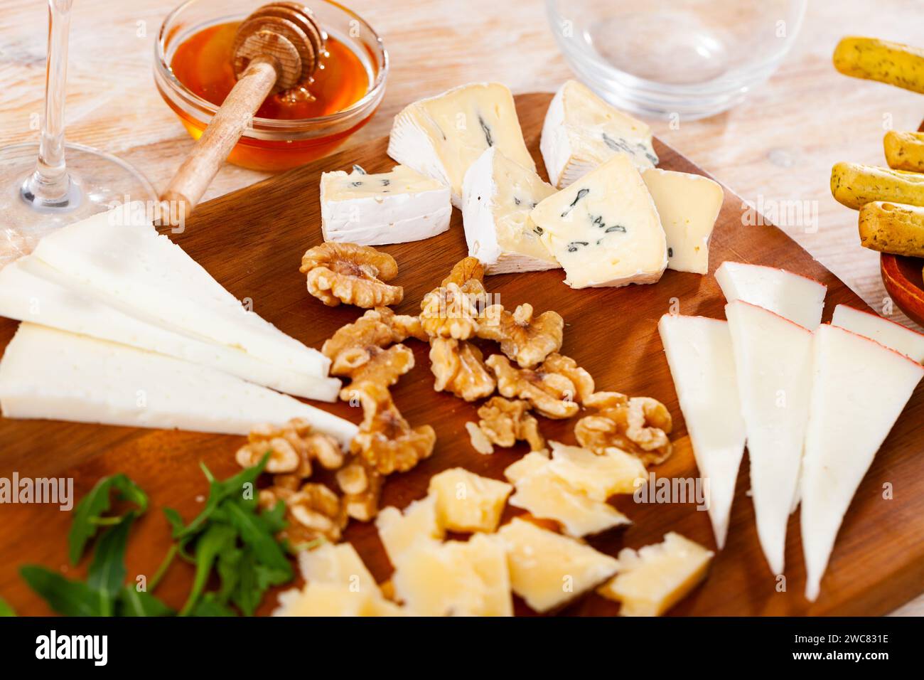 Différents types de fromage servis sur bois avec du miel, des tranches de noix Banque D'Images
