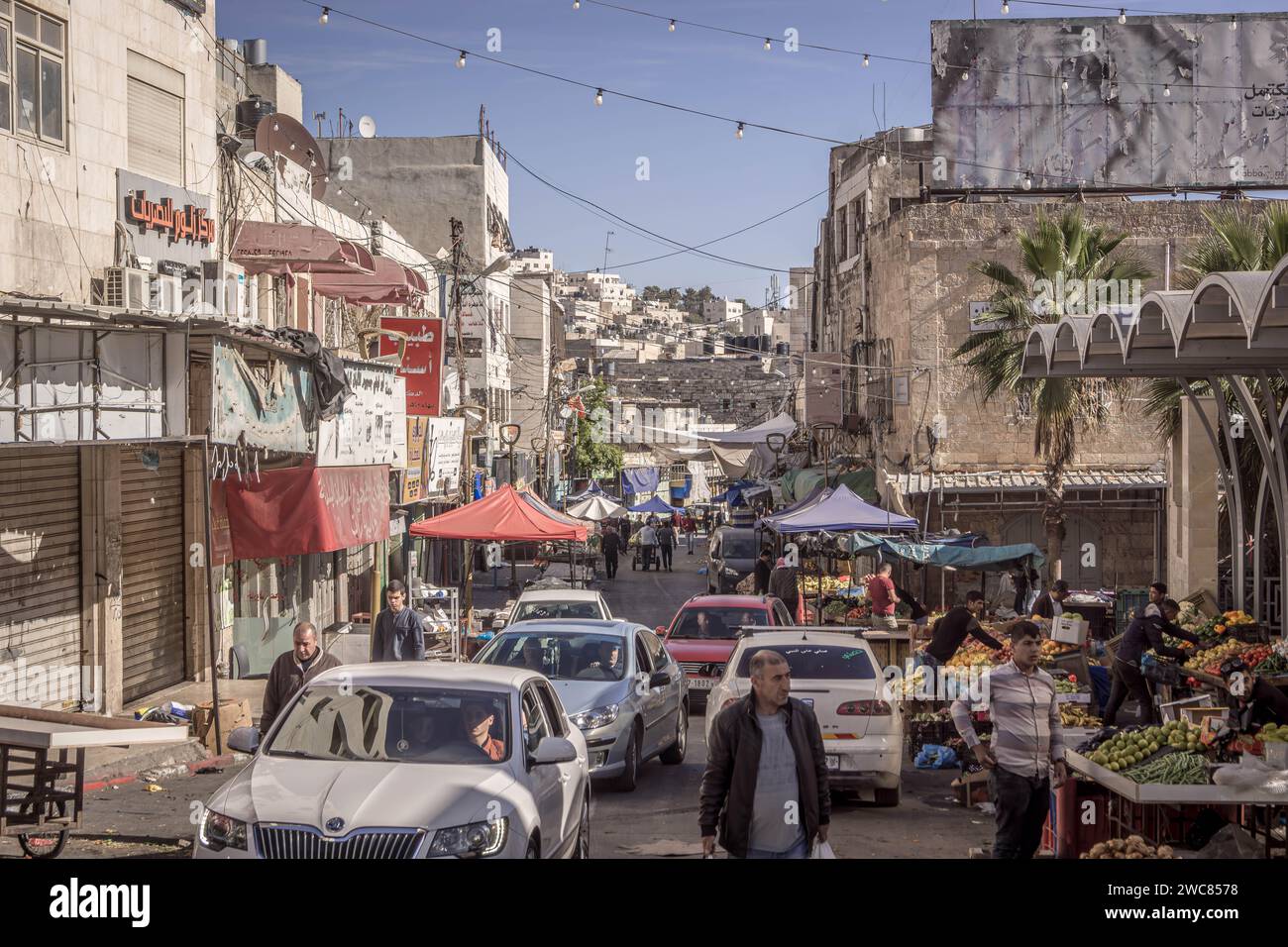 Les rues de la ville de Bethléem, Cisjordanie, Palestine, avec des voitures, des bâtiments, les magasins des vendeurs, la circulation et les Palestiniens locaux qui passent. Banque D'Images