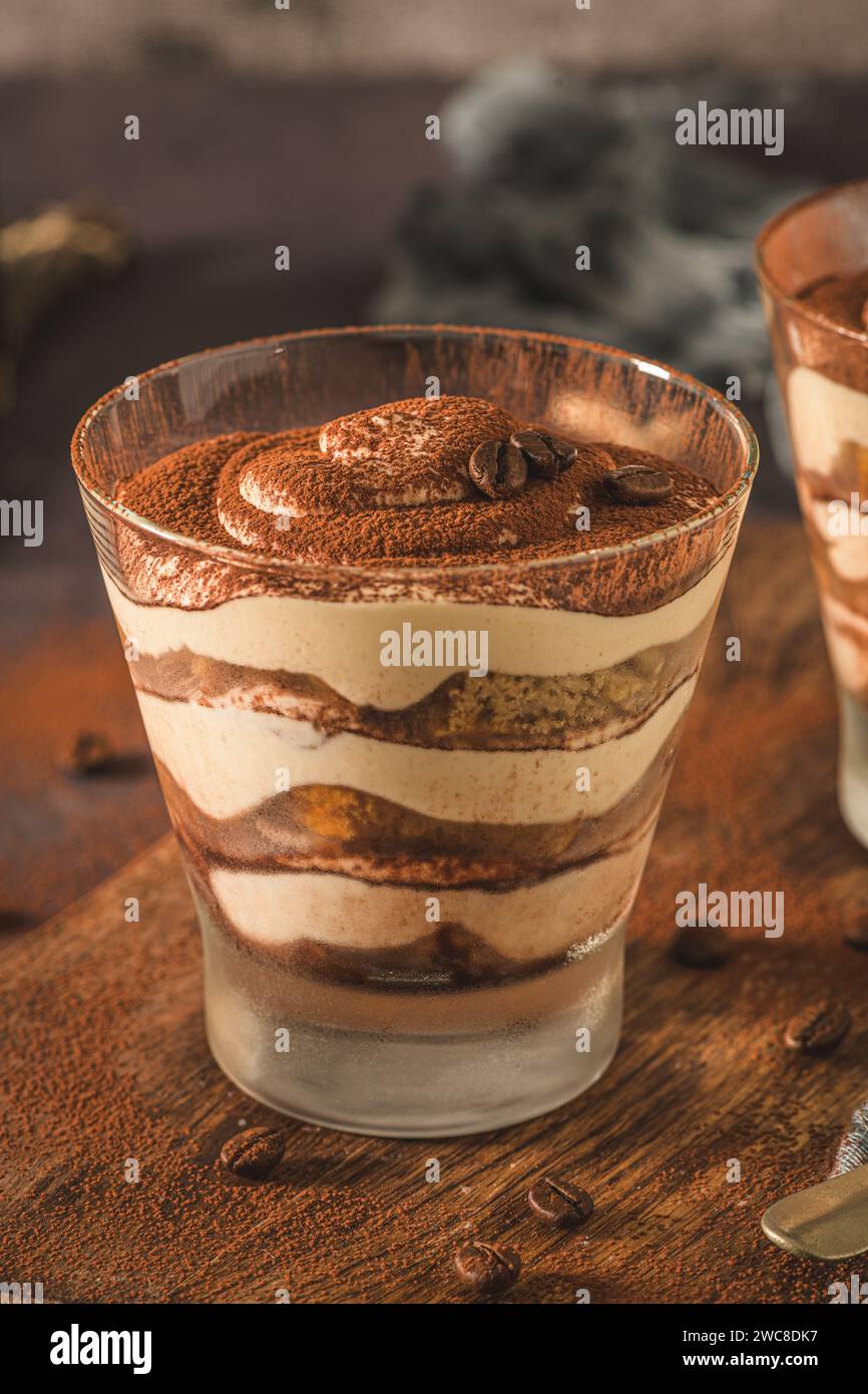 Délicieux dessert italien tiramisu dans un verre sur un fond d'ardoise sombre, de pierre ou de béton. Banque D'Images