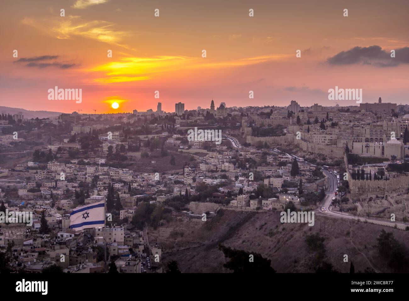 Le magnifique coucher de soleil sur la vieille ville de Jérusalem avec le drapeau israélien au premier plan depuis le Mont des oliviers, en Israël, au moyen-Orient. Banque D'Images