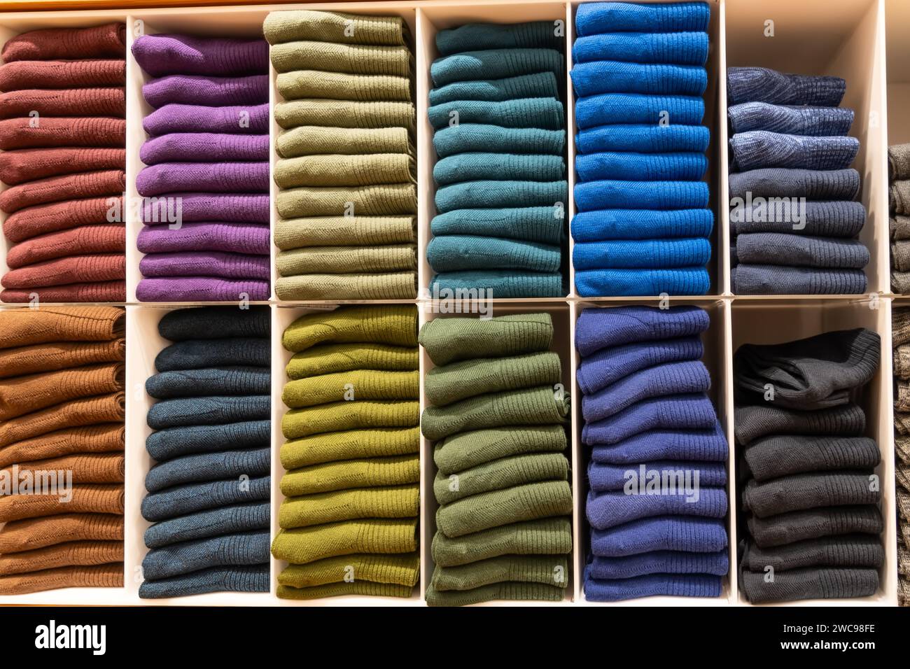 Piles de chaussettes et de modèles de différentes couleurs sur une étagère de magasin. Banque D'Images