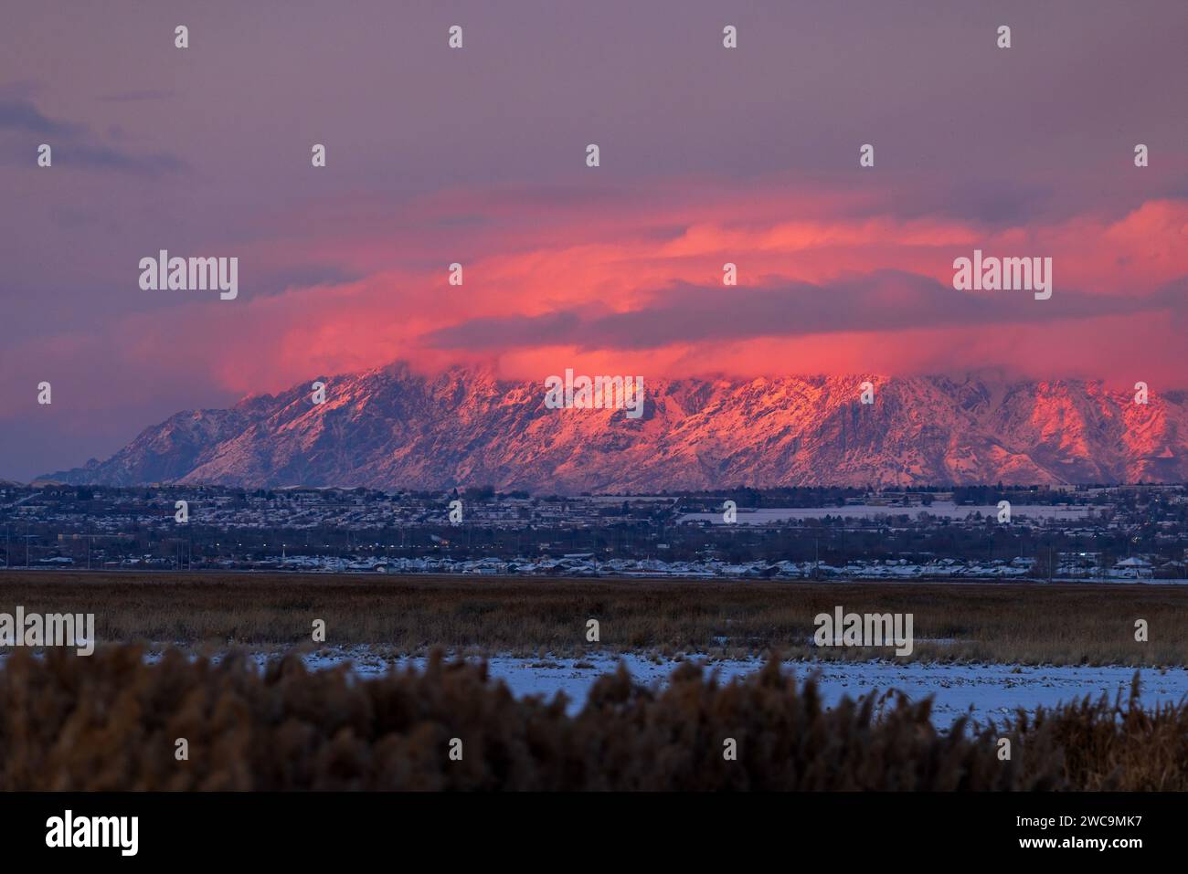 La rémanence du soleil couchant projette une lumière rose sur les nuages et le mont Ben Lomond.sur le côté nord d'Ogden, comté de Weber, Utah, États-Unis. Banque D'Images