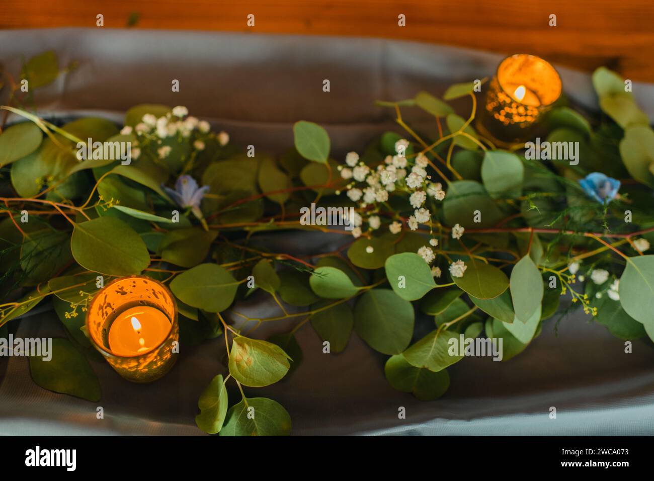 Réglage de table de feuilles d'eucalyptus et de bougies sur un chemin de table Banque D'Images