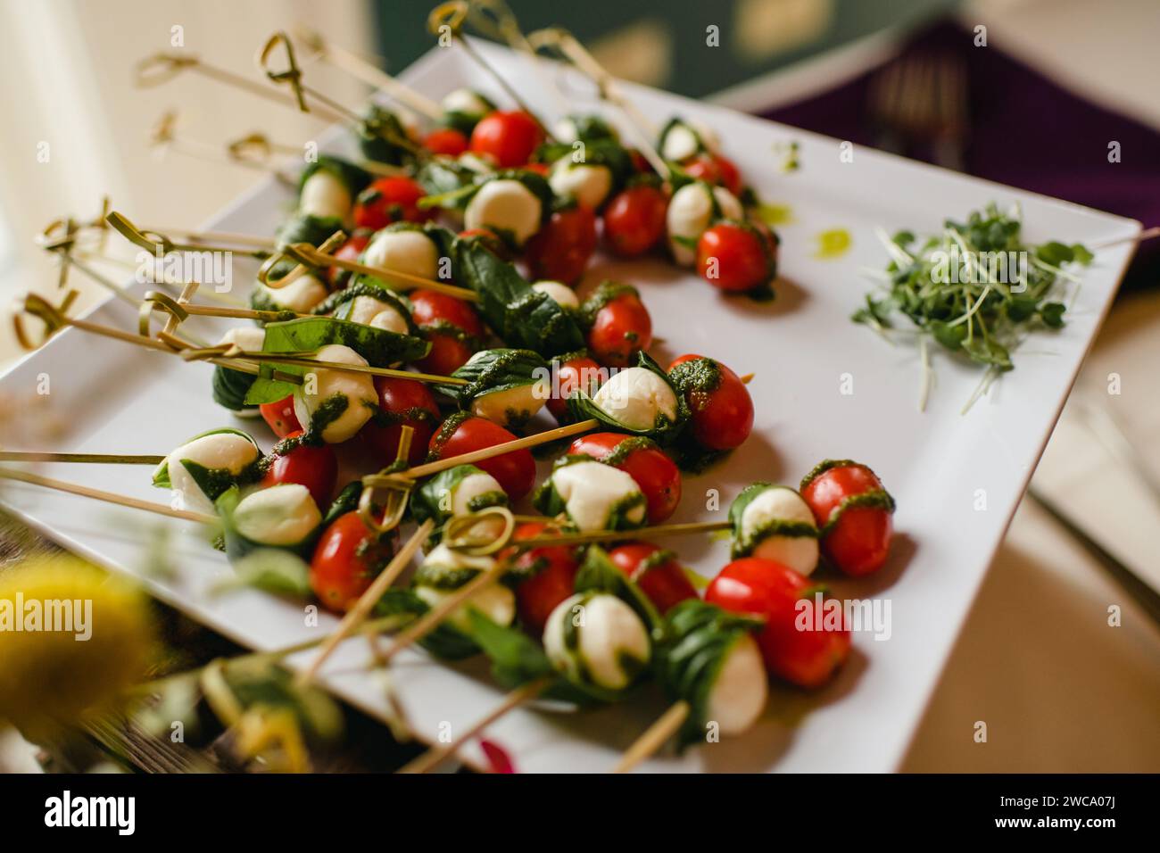 Brochettes Caprese avec tomates, mozzarella et basilic sur l'assiette de service Banque D'Images