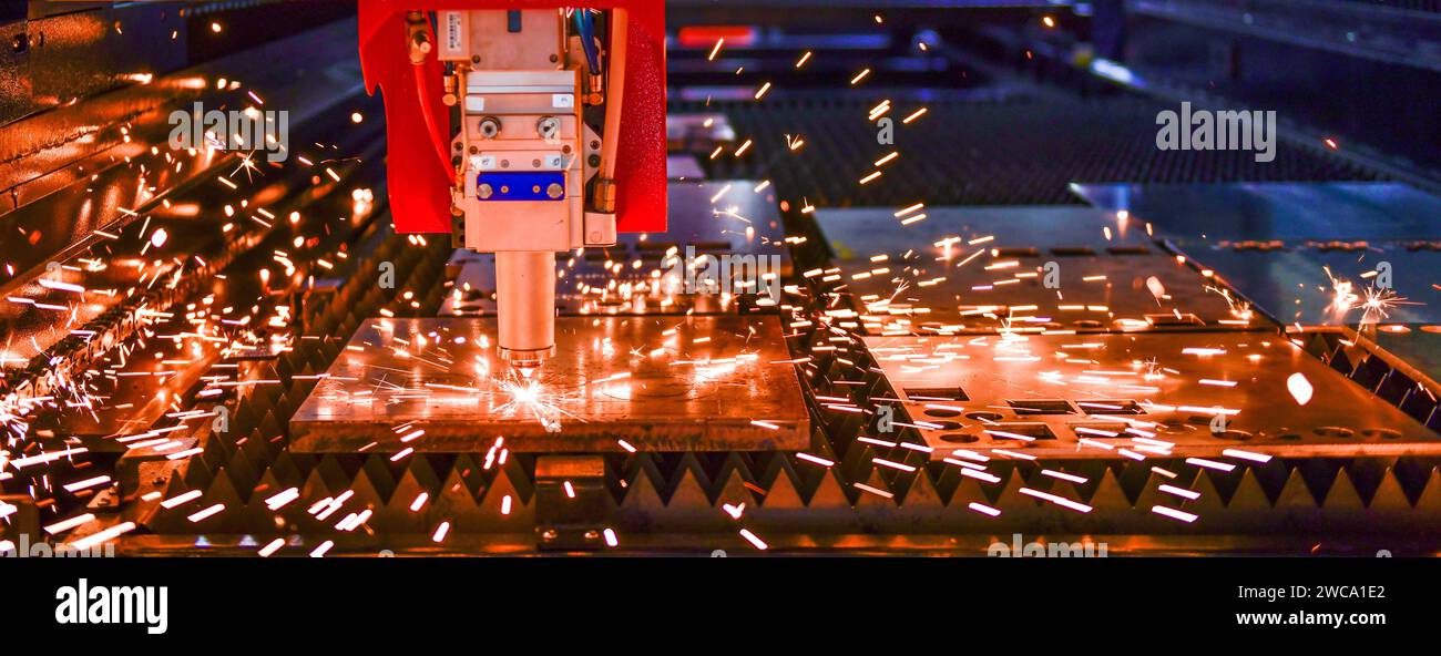 Machine de coupe laser industriel tout en réduisant la tôle avec les étincelles de lumière. Banque D'Images