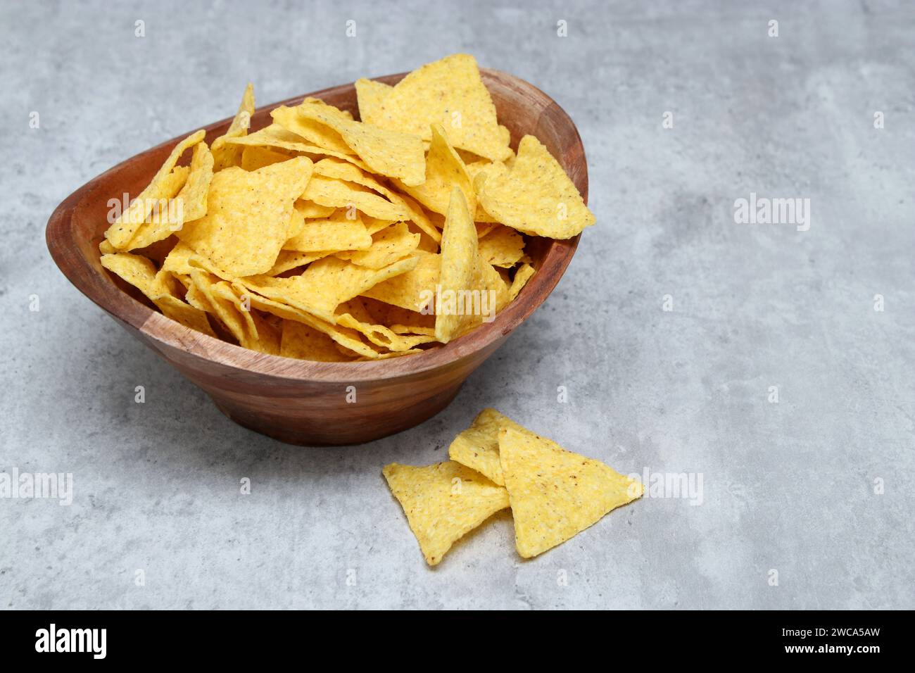 Tortilla salée dans un bol en bois, table en marbre gris avec espace copie Banque D'Images