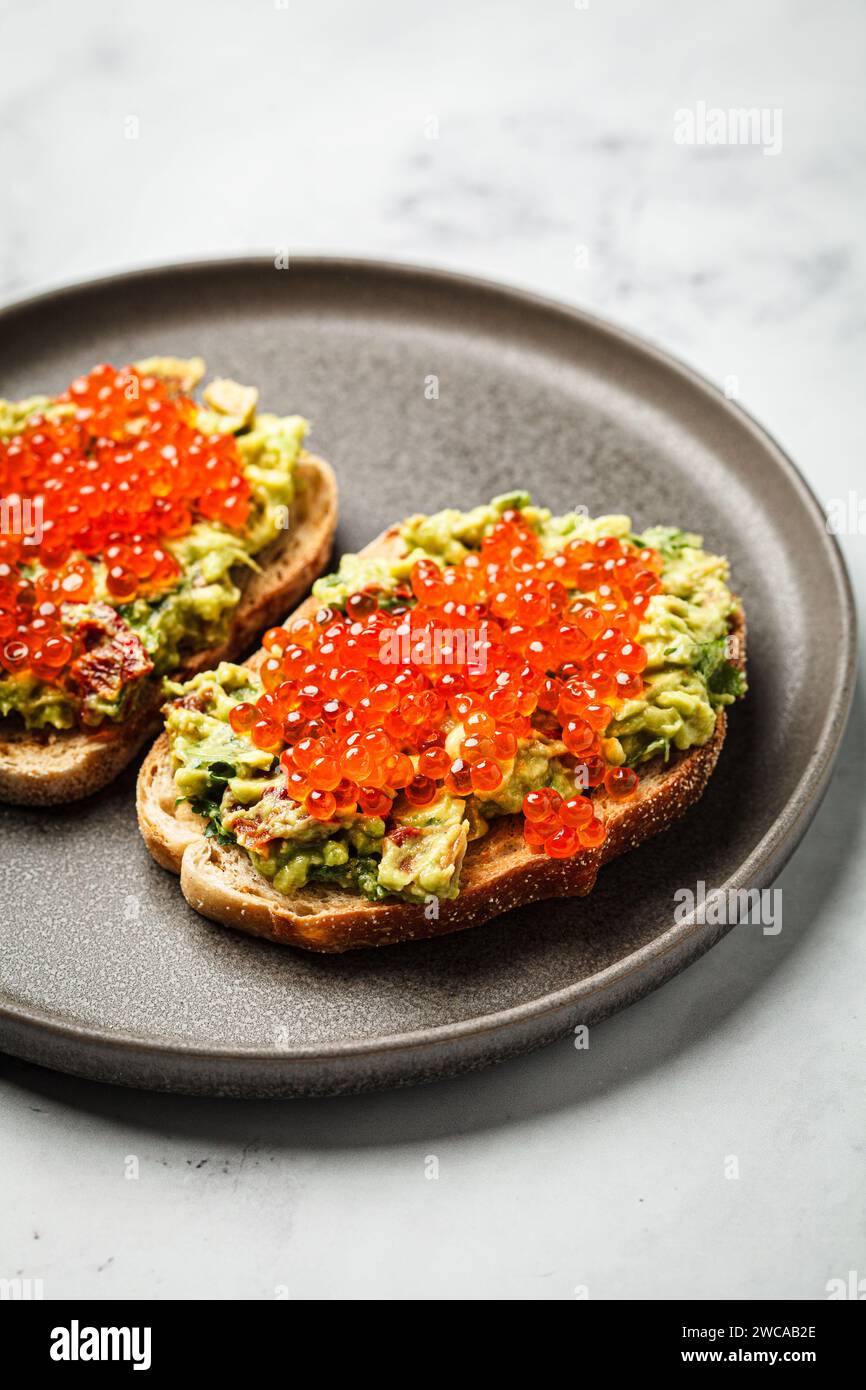 Caviar rouge et pain de guacamole d'avocat grillé avec pain de seigle, gros plan, . Banque D'Images