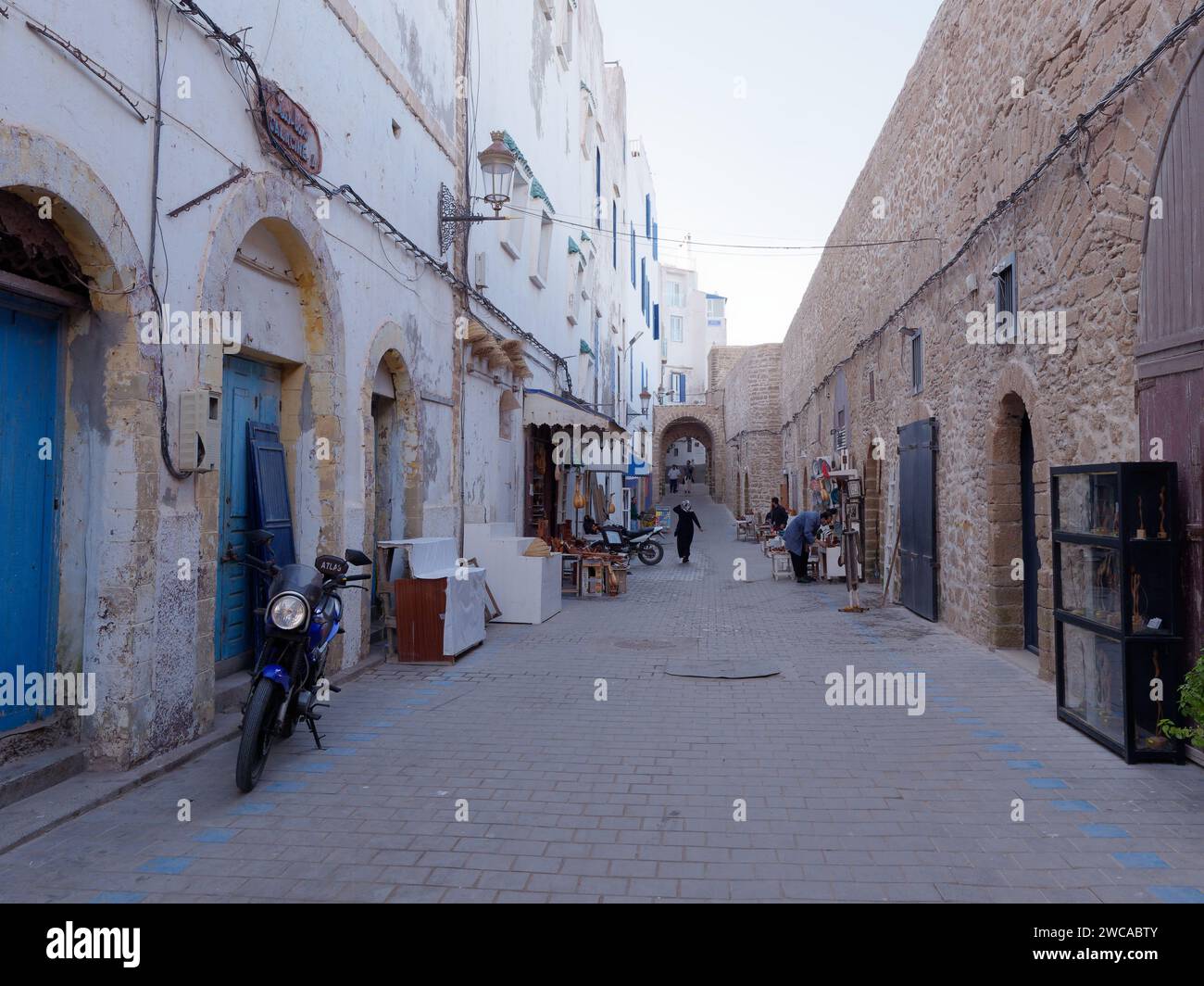 Rue étroite dans la médina que les magasins sont sur le point d'ouvrir le matin avec le mur de la ville à droite, à Essaouira Maroc, 14 janvier 2024 Banque D'Images
