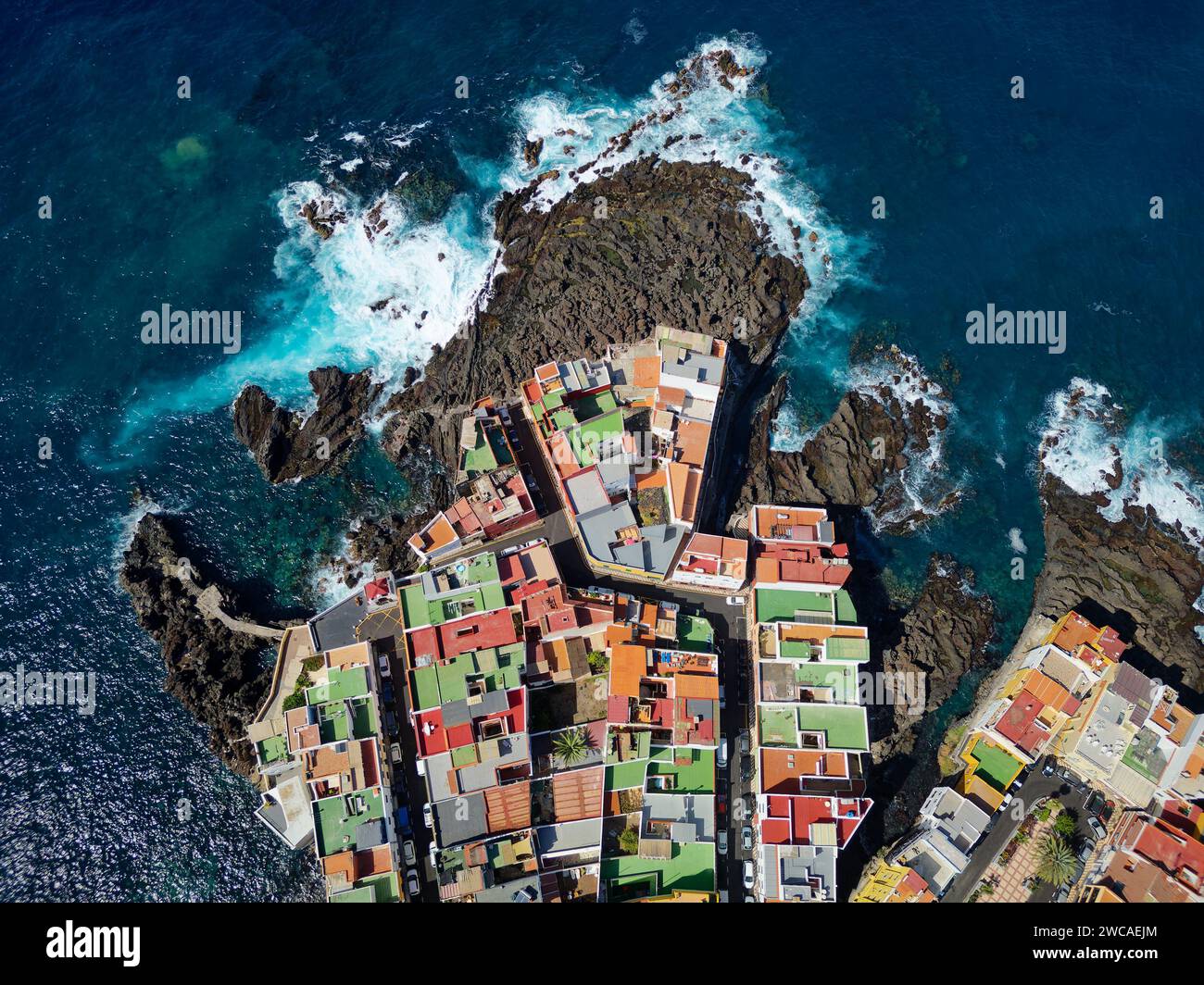 Vue aérienne de Punta Brava à Tenerife, îles Canaries, Espagne. Maisons colorées et rochers de lave noire dans un petit village de pêcheurs. Banque D'Images