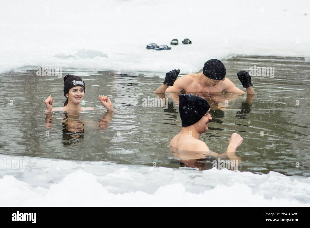 Jeunes amis baignant de glace dans l'eau froide d'un lac gelé. Méthode Wim Hof, thérapie par le froid, techniques de respiration, yoga et méditation Banque D'Images