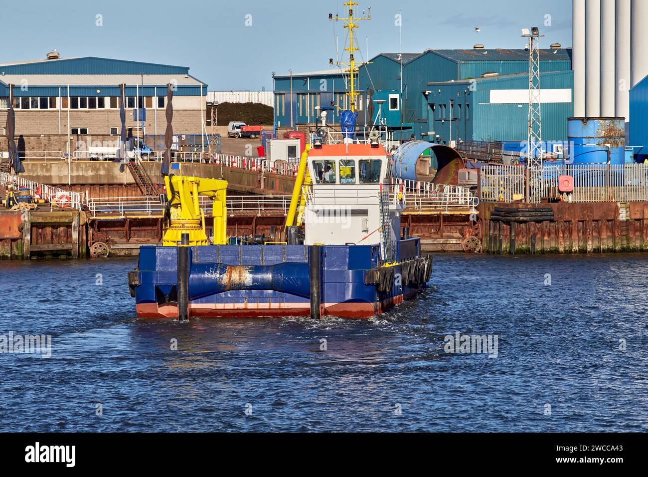 Navire dragueur travaillant dans le port maritime pendant la journée ensoleillée. Banque D'Images