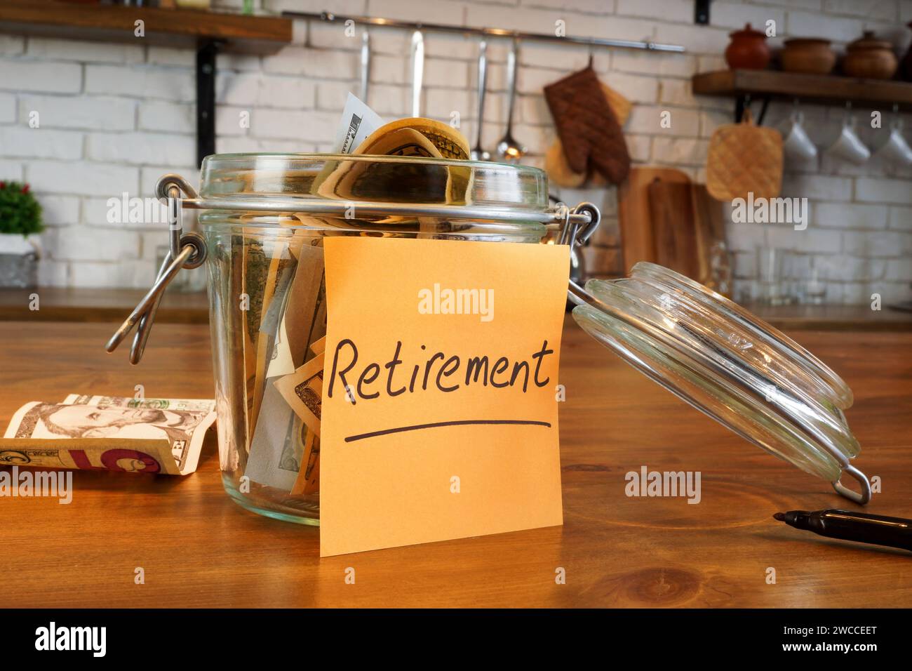 Un bocal en verre avec de l'épargne-retraite est sur la table. Banque D'Images