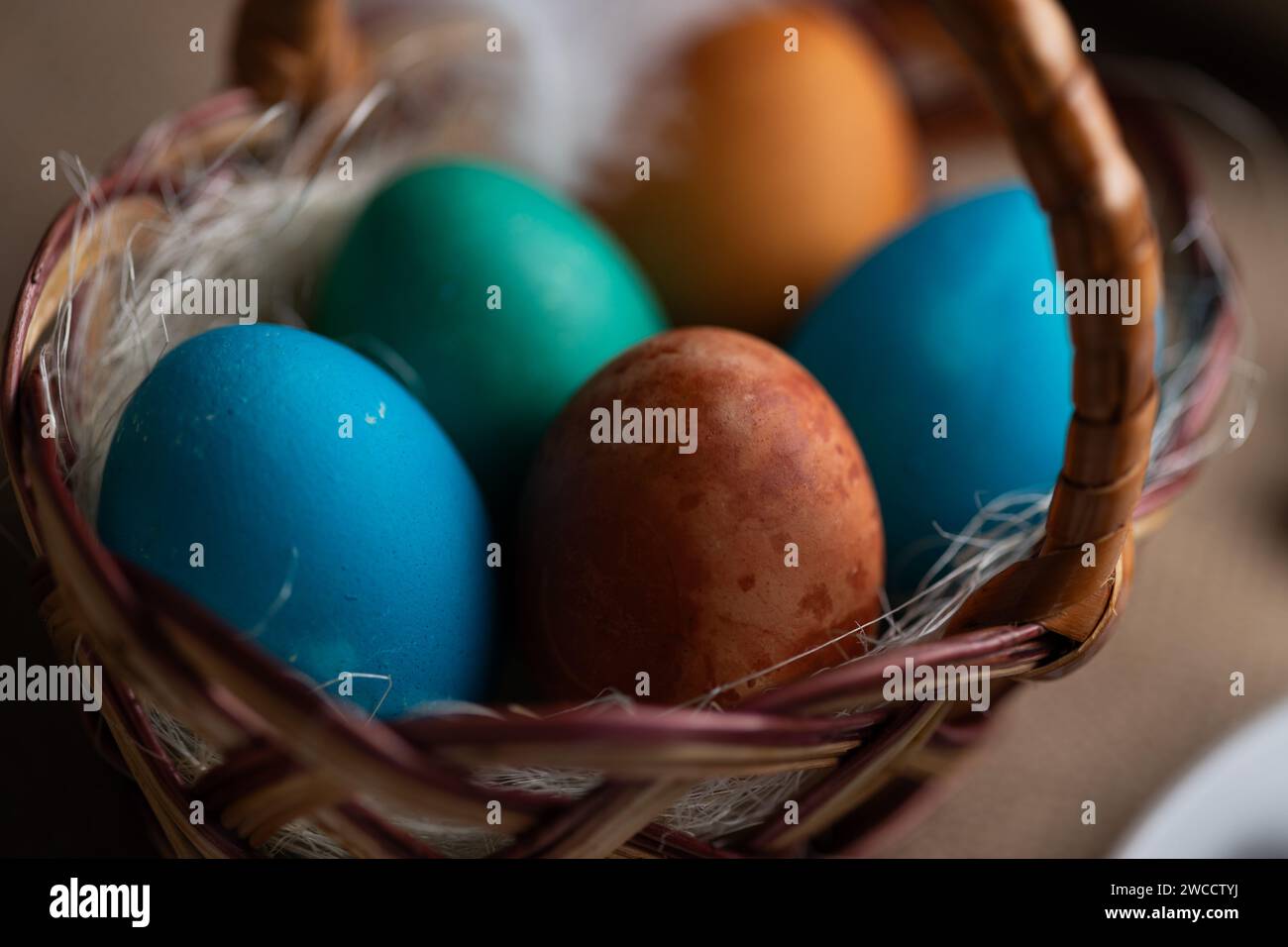 Gros plan d'œufs de Pâques multicolores dans un panier en osier Banque D'Images