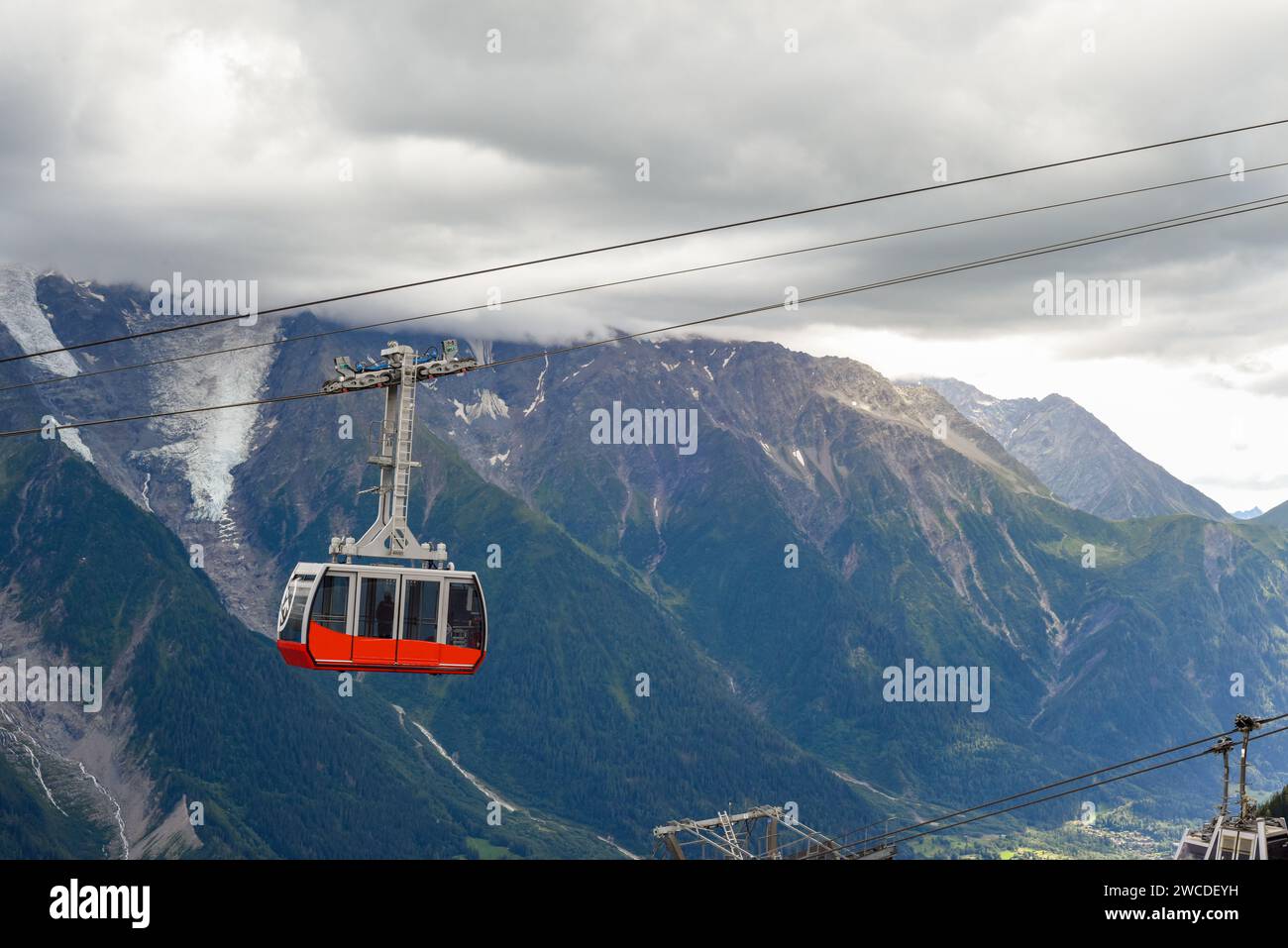 Une personne monte un téléphérique au-dessus des montagnes d'une station de ski Banque D'Images
