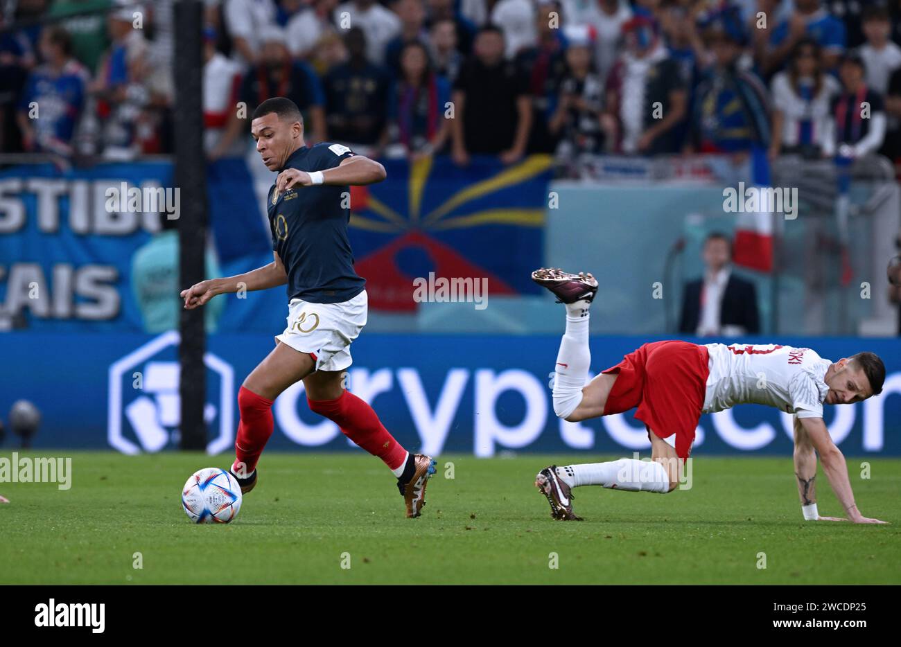 Kylian Mbappé met le pas sur un joueur polonais lors de la victoire de la France au tour 3-1 des 16 contre la Pologne lors de la coupe du monde Qatar FIFA 2022. Banque D'Images