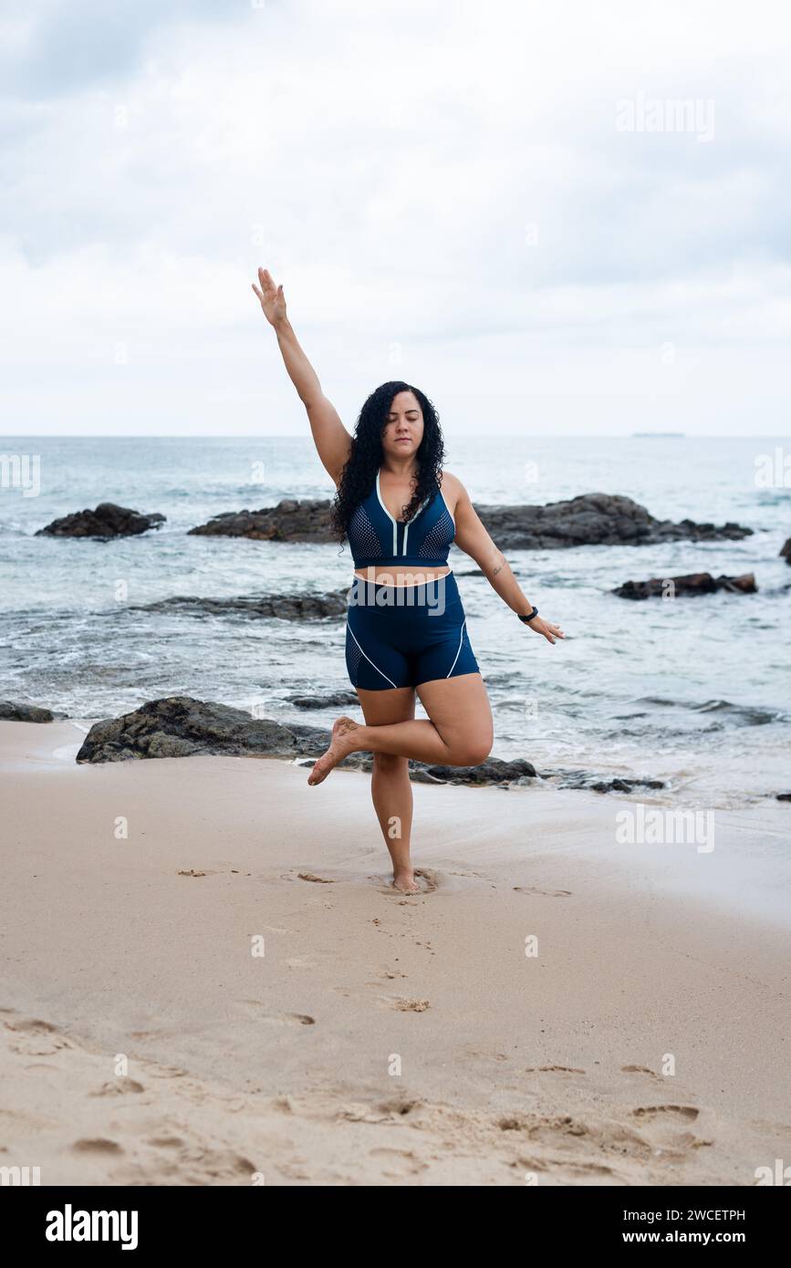 Femme de fitness, athlète, faisant des exercices d'équilibre sur le sable de plage. Mode de vie sain. Banque D'Images