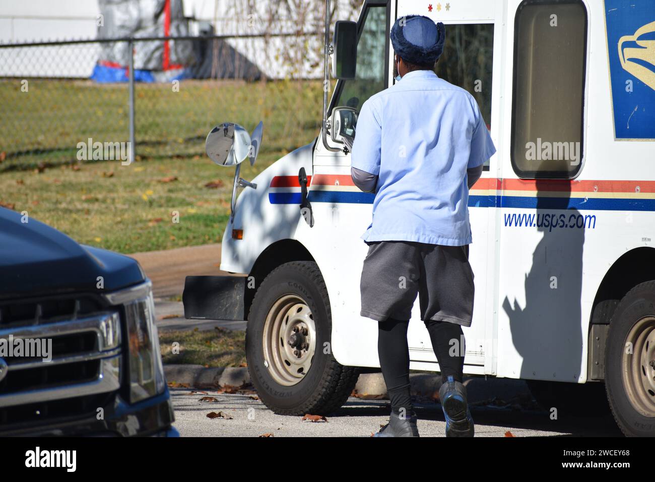 Un Mailman des États-Unis marchant vers son camion postal par une journée ensoleillée - novembre 2023 Banque D'Images