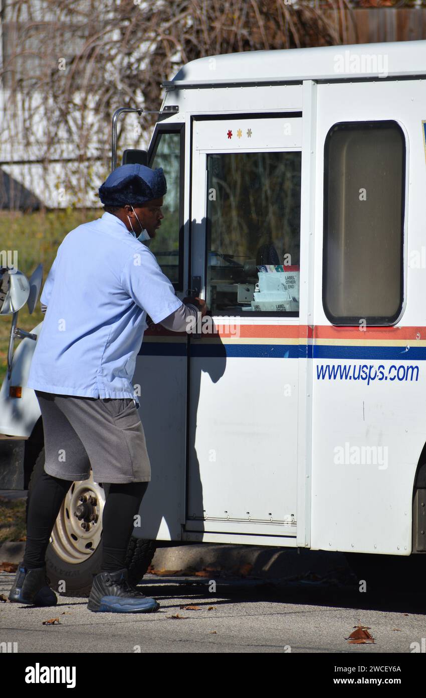 Un Mailman des États-Unis marchant vers son camion postal par une journée ensoleillée - novembre 2023 Banque D'Images