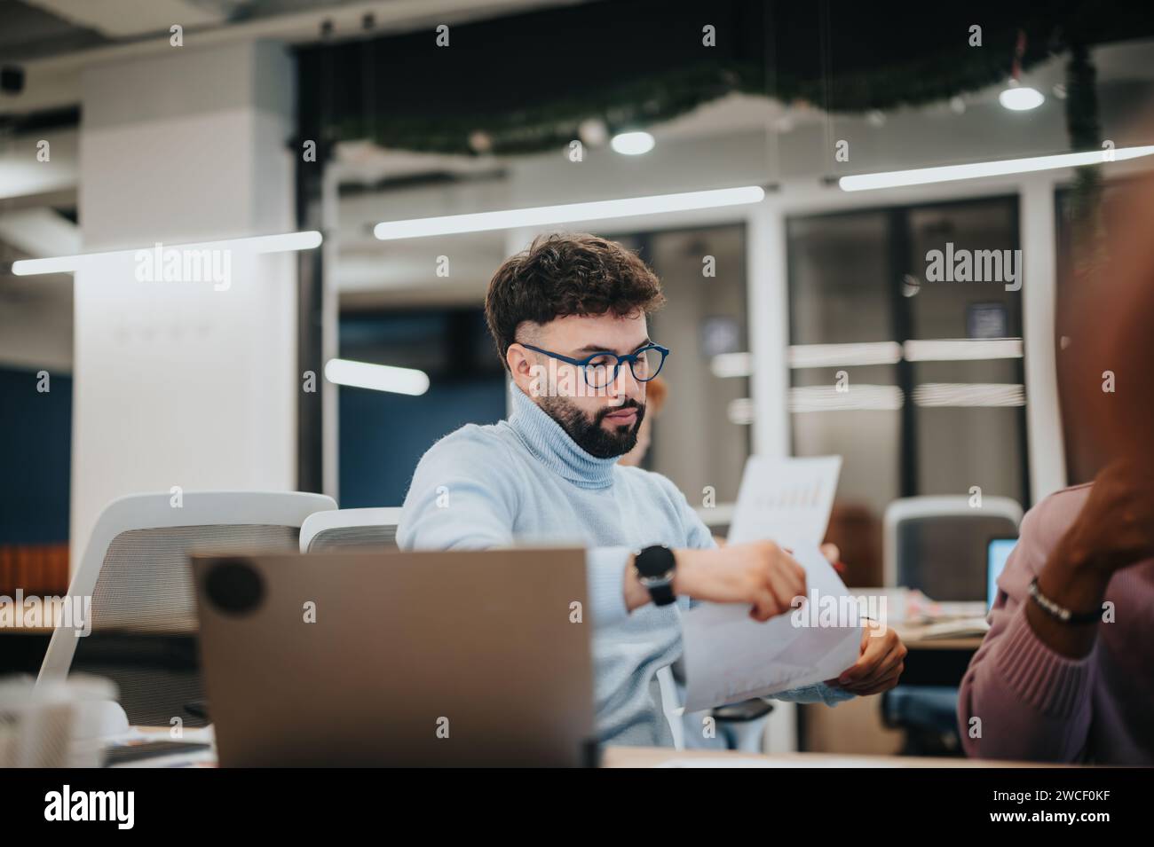 Les professionnels collaborent, examinent les statistiques et planifient les tâches dans une atmosphère de bureau agréable. Banque D'Images