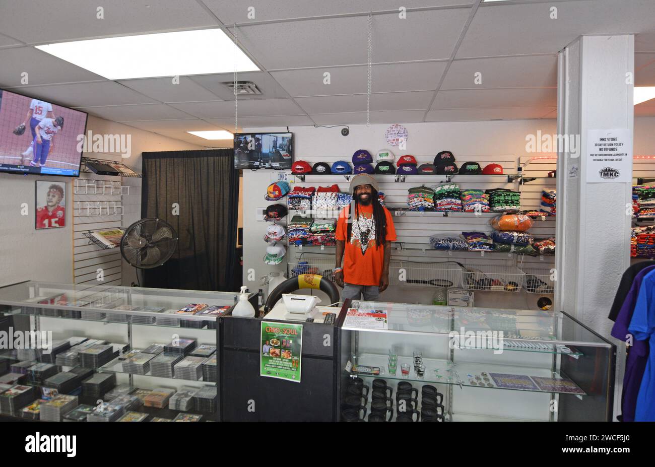 Homme rastafarien dans un magasin de vêtements et casquettes de baseball dans le quartier historique 18th and Vine District à Kansas City Missouri - mai 2023 Banque D'Images
