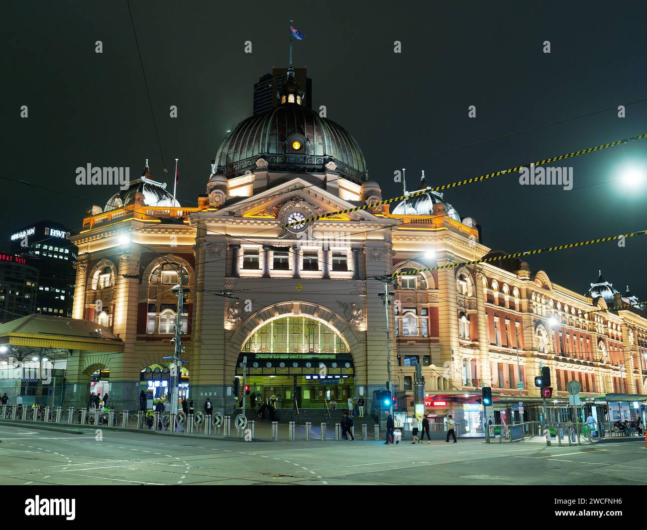 Vue colorée de la gare de Flinders Street située au coin animé de Flinders Street et Swanston Streets illuminée la nuit à Melbourne en Australie. Banque D'Images