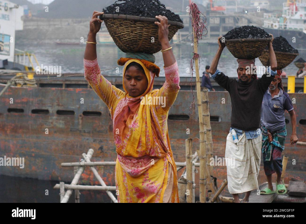Dhaka, Bangladesh. 16 janvier 2024. Les travailleurs déchargent le charbon d'un cargo sur un marché de gros de charbon à Dhaka. (Image de crédit : © MD Mehedi Hasan/ZUMA Press Wire) USAGE ÉDITORIAL SEULEMENT! Non destiné à UN USAGE commercial ! Banque D'Images
