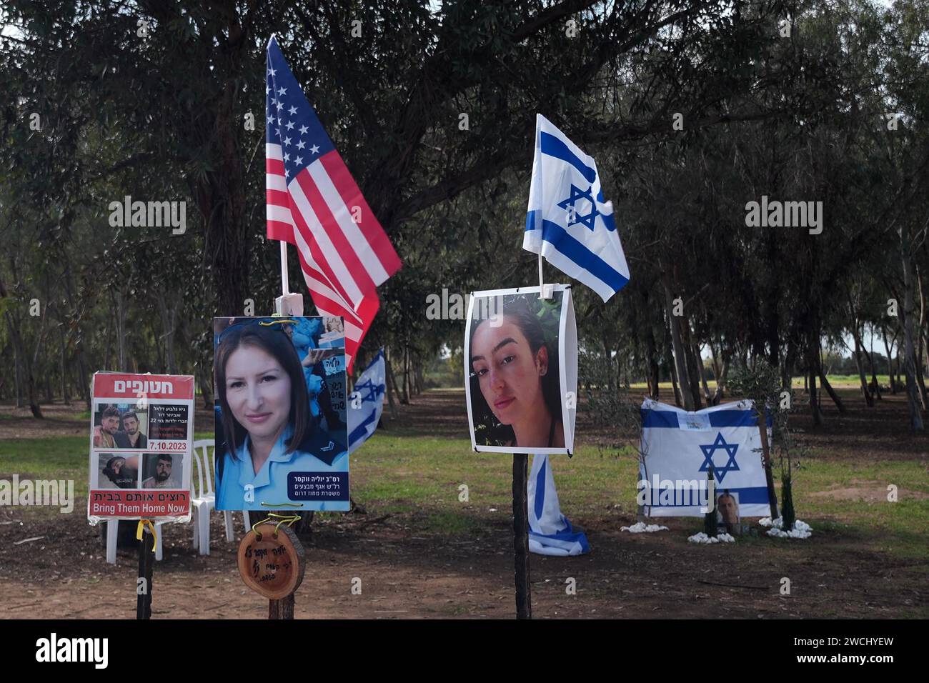 Le drapeau des États-Unis et israélien se dresse devant une installation portant des portraits de personnes israéliennes prises en captivité ou tuées par des militants du Hamas lors des attaques du 7 octobre sur le site où le festival de musique Supernova a eu lieu près du kibboutz Reim au milieu des combats continus entre Israël et le militant groupe Hamas le 14 janvier 2024 à la frontière de Gaza, Israël Banque D'Images