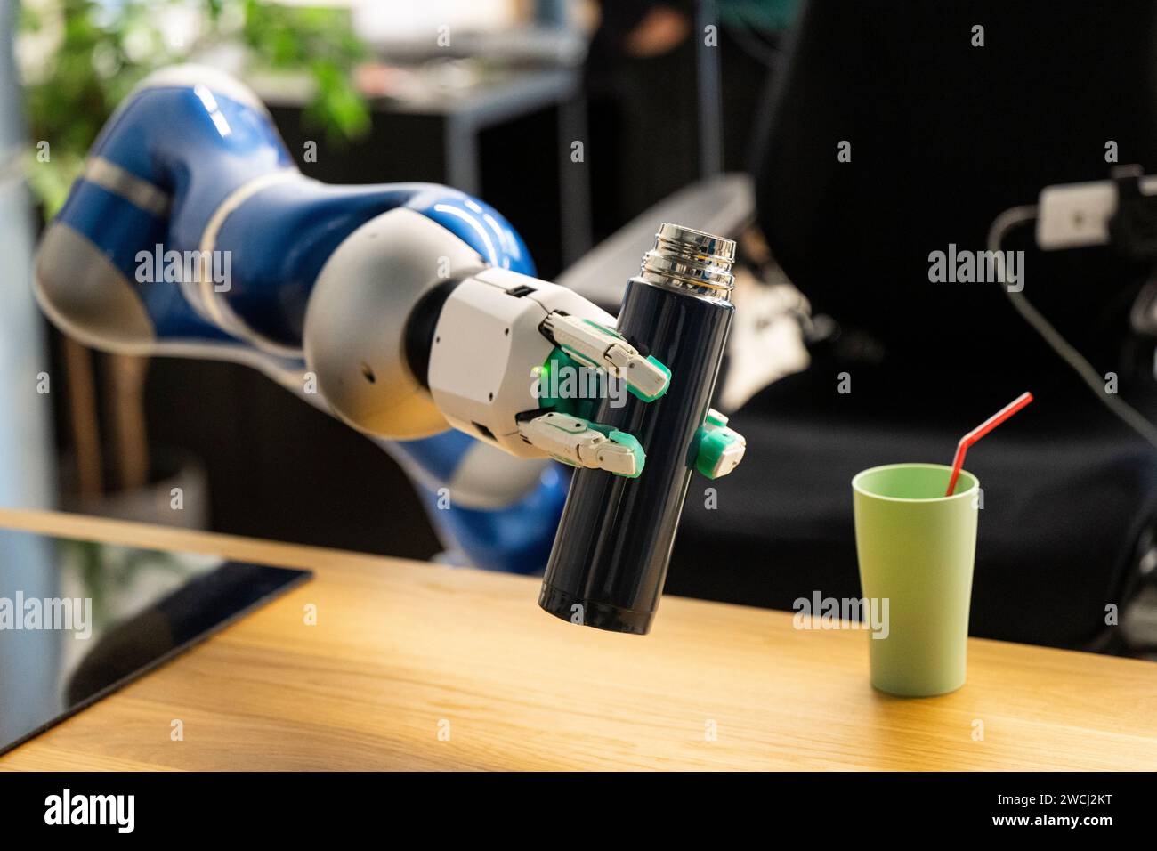 16 janvier 2024, Bavière, Weßling : le bras de préhension d'un robot humanoïde destiné à être utilisé dans les soins atteint une bouteille à l'Institut de robotique et de mécatronique du Centre aérospatial allemand. Photo : Lennart Preiss/dpa Banque D'Images