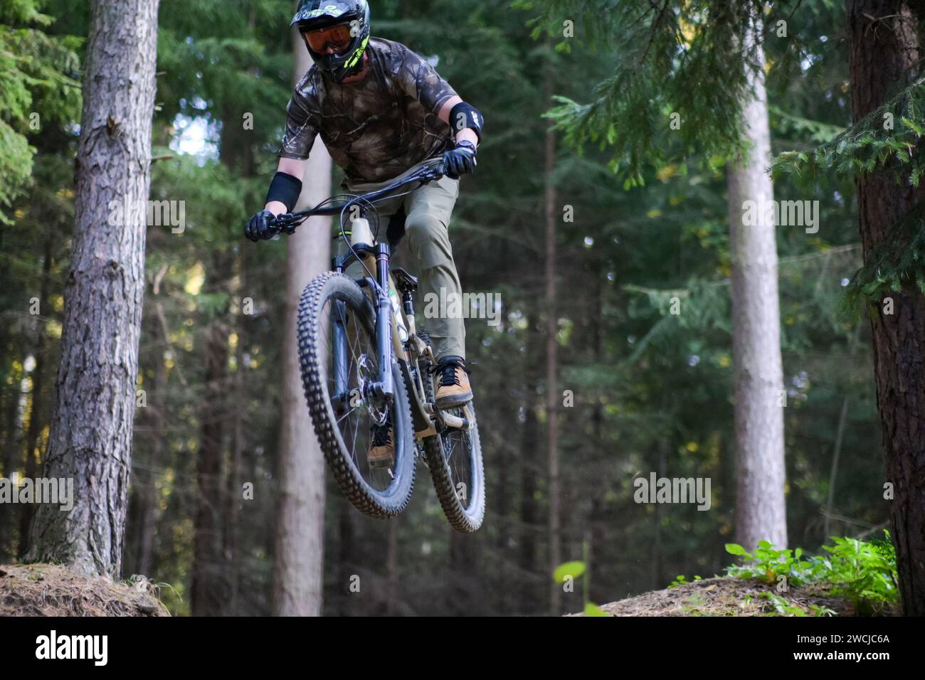 Athlète professionnel saut en hauteur sur un vélo de montagne dans la forêt, vue rapprochée. Banque D'Images