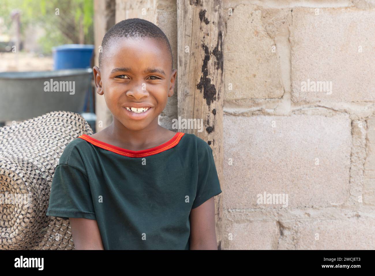 portrait jeune enfant africain dans le village, un chapeau et la maison en arrière-plan Banque D'Images