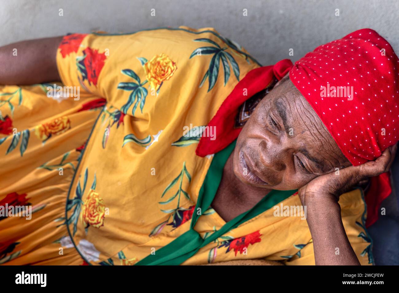 vieille femme africaine dans le village reposant devant la maison Banque D'Images