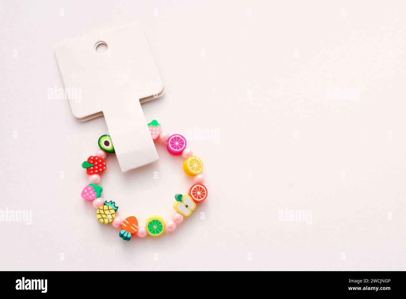 Bracelet coloré avec étiquette et perles en forme de fruits Banque D'Images