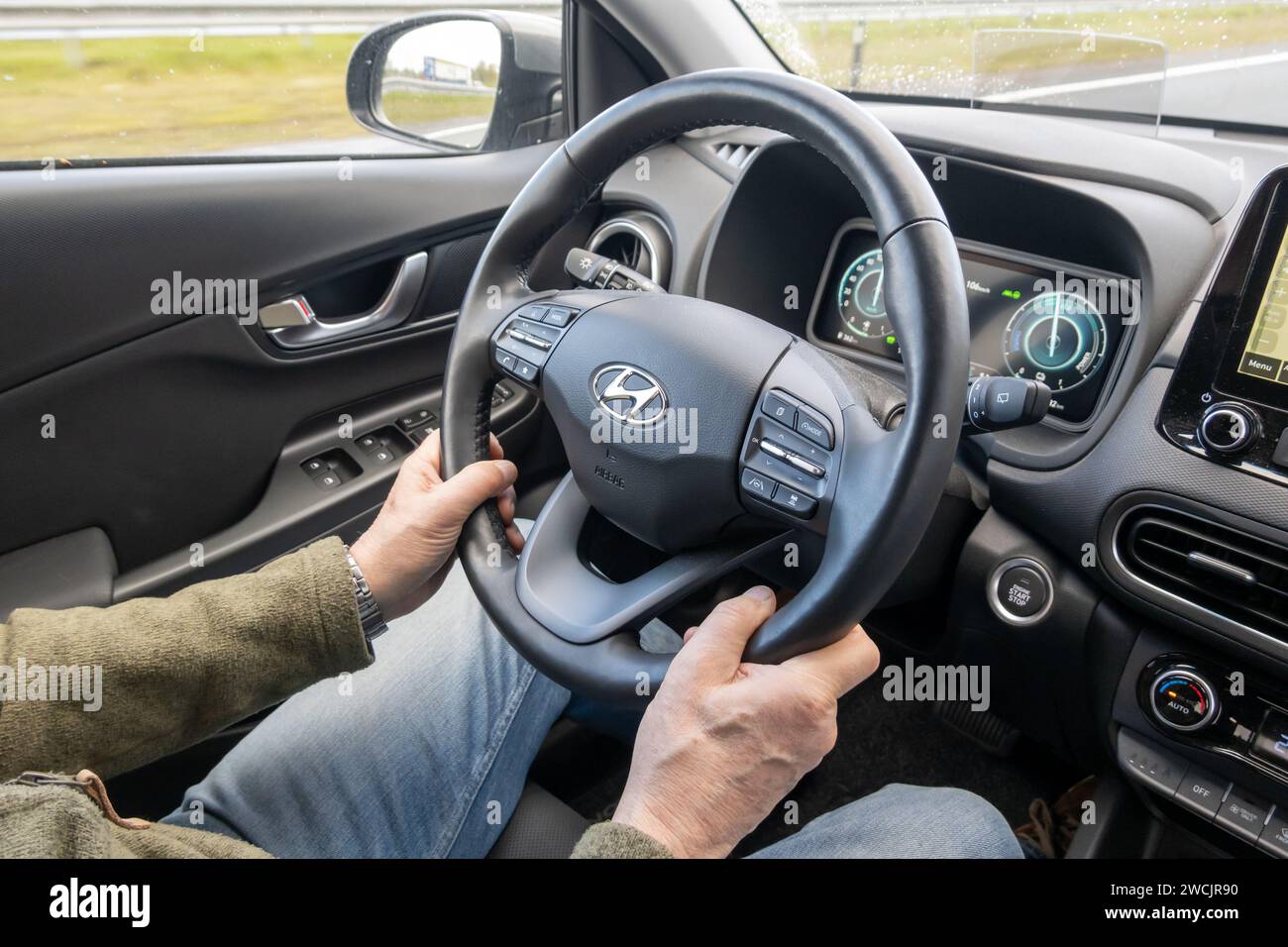 Conducteur utilisant le régulateur de vitesse au volant tout en conduisant une voiture. Intérieur de Hyundai Kona hybride. Banque D'Images