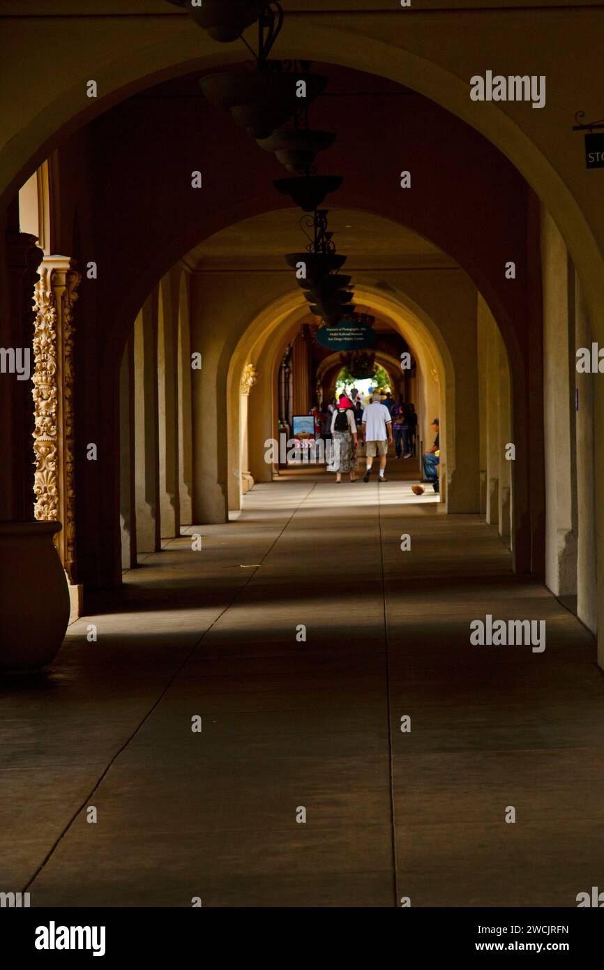 Passerelle voûtée avec des gens se promenant dans un corridor de bâtiment historique Banque D'Images