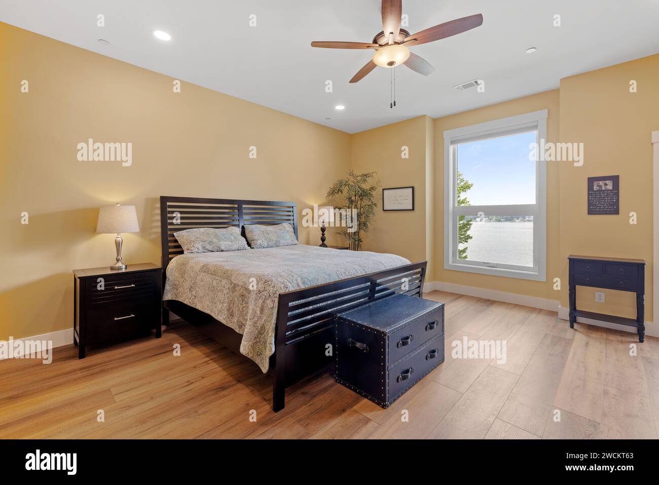 Chambre confortable avec un mobilier élégant, y compris des armoires et un ventilateur de plafond Banque D'Images