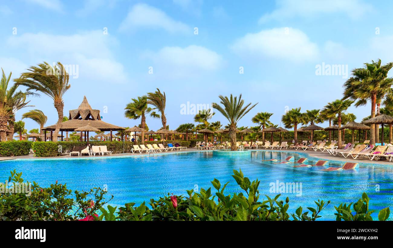 Boa Vista, Cap-vert-22 mars 2018 : une journée ensoleillée à la piscine d'un hôtel Boa Vista avec des palmiers, des parasols et un bar tropical animé. Banque D'Images