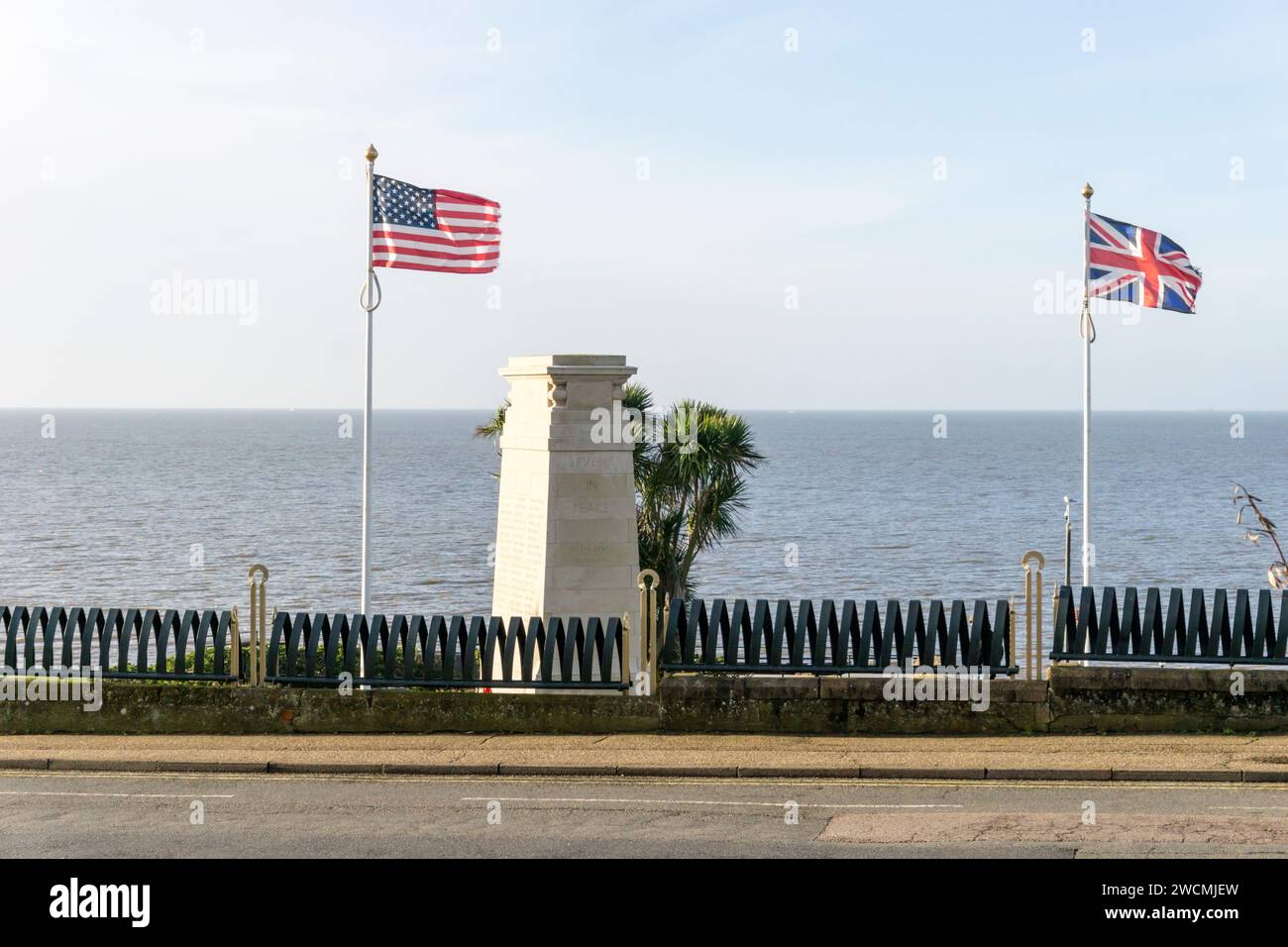 Les drapeaux britanniques et américains flottent à côté du monument aux morts sur la falaise de Hunstanton dans le Norfolk. Banque D'Images